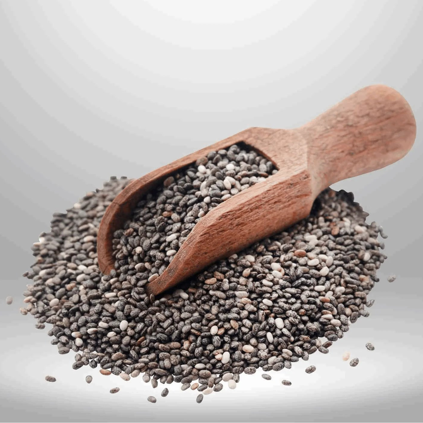 Wooden scoop filled with chia seeds on a light gray background